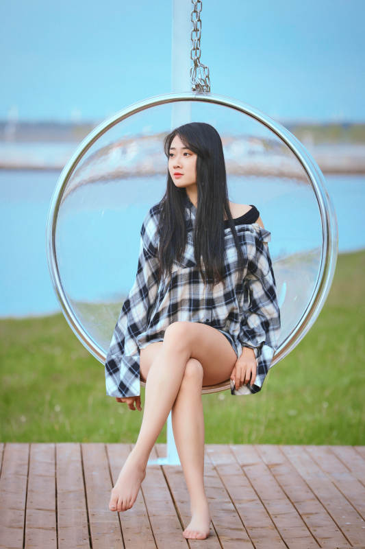 草原湖畔坐在透明秋千里的亚洲年轻女性人像图片