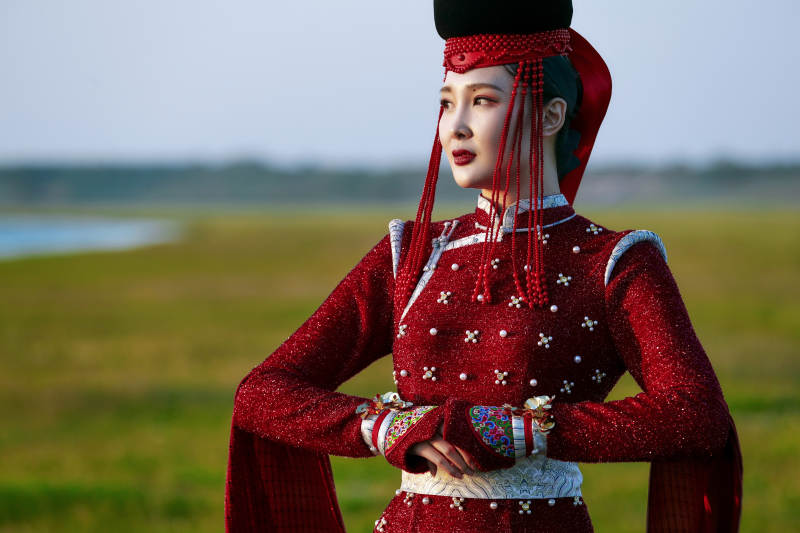 草原上穿着蒙古族传统服饰的亚洲年轻美少女图片