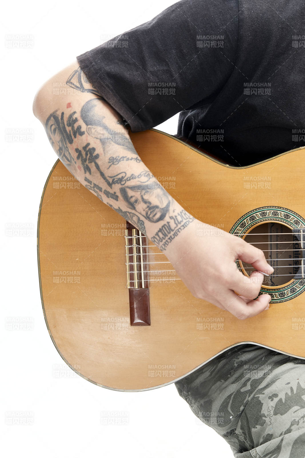 示范演奏古典吉他的亚洲男性乐手人像局部特写图片