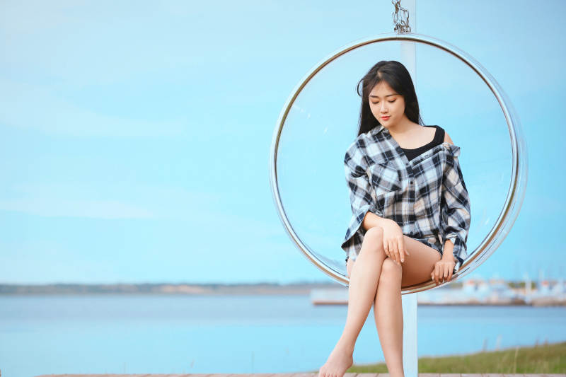 草原湖畔坐在透明秋千里的亚洲年轻女性人像图片