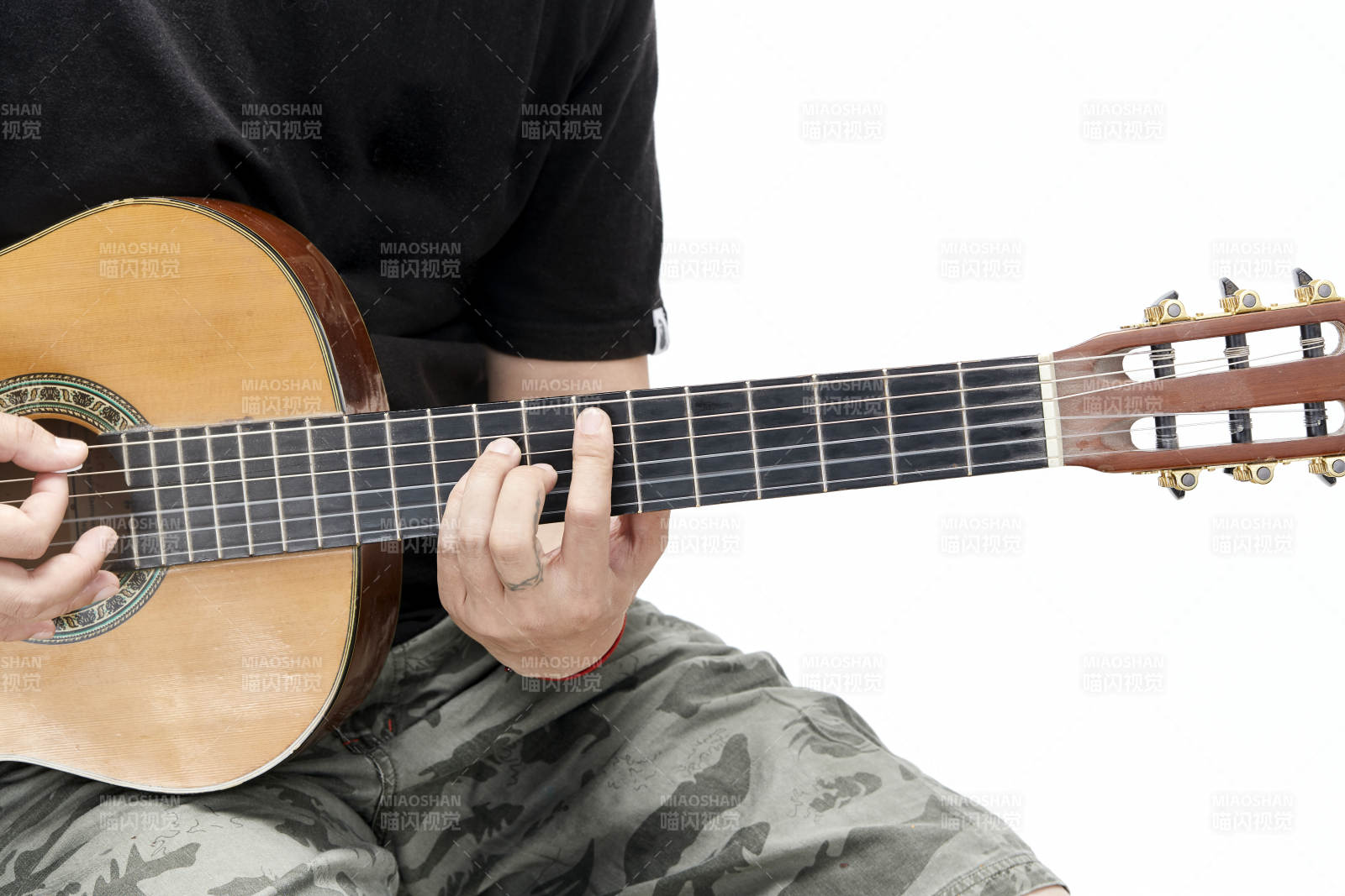 示范演奏古典吉他的亚洲男性乐手人像局部特写图片