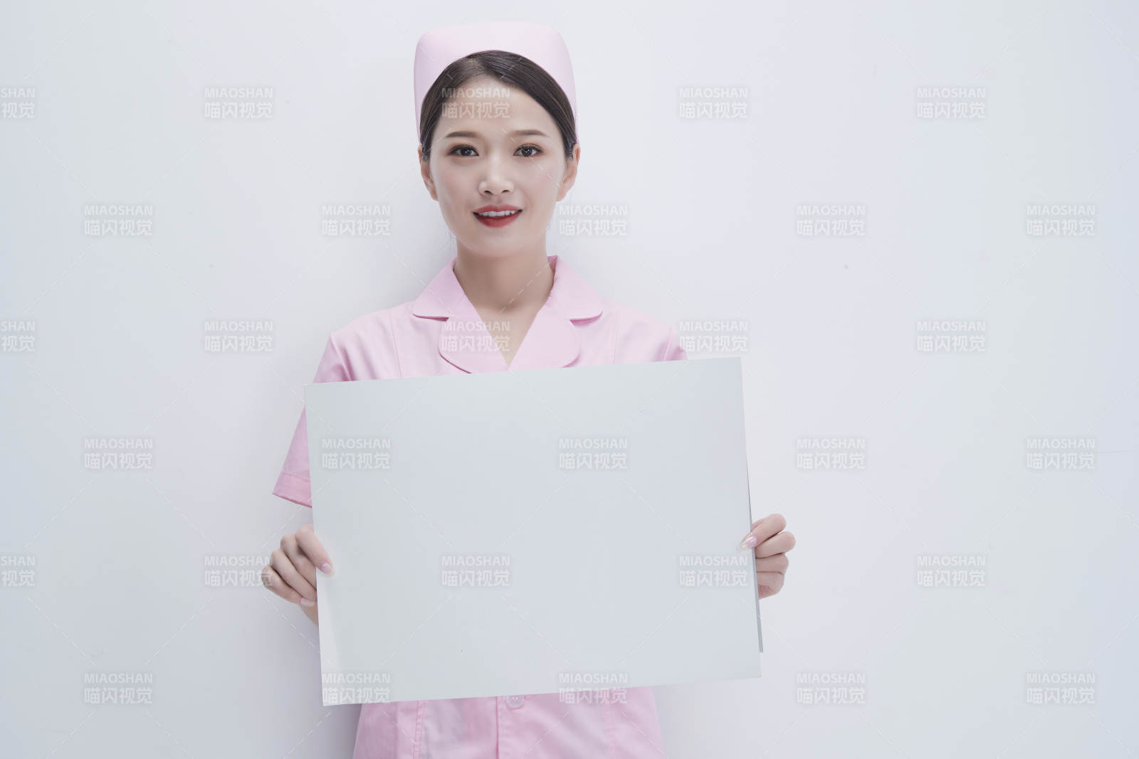 身穿粉色护士服佩戴听诊器的女性医护人员图片