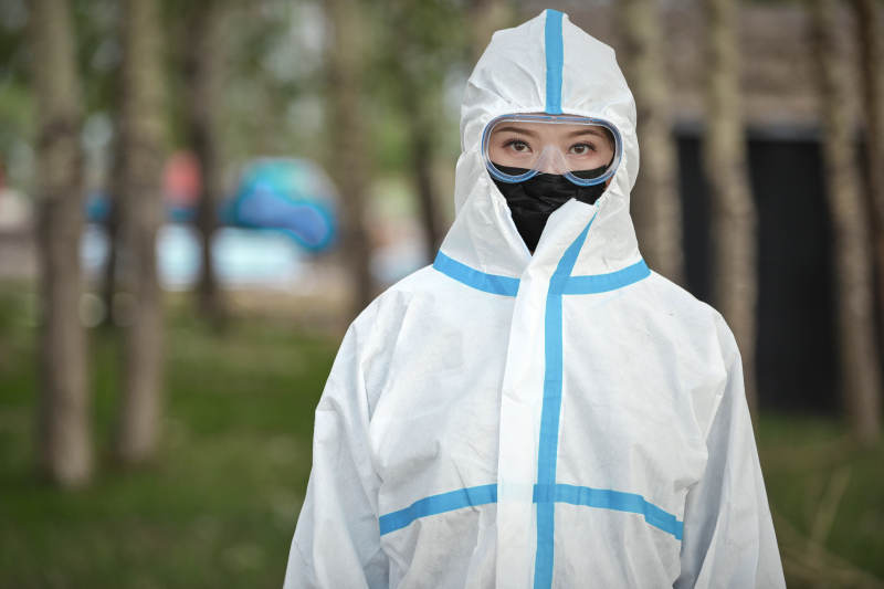 穿白色防护服佩戴护目镜口罩的女性防护人员图片