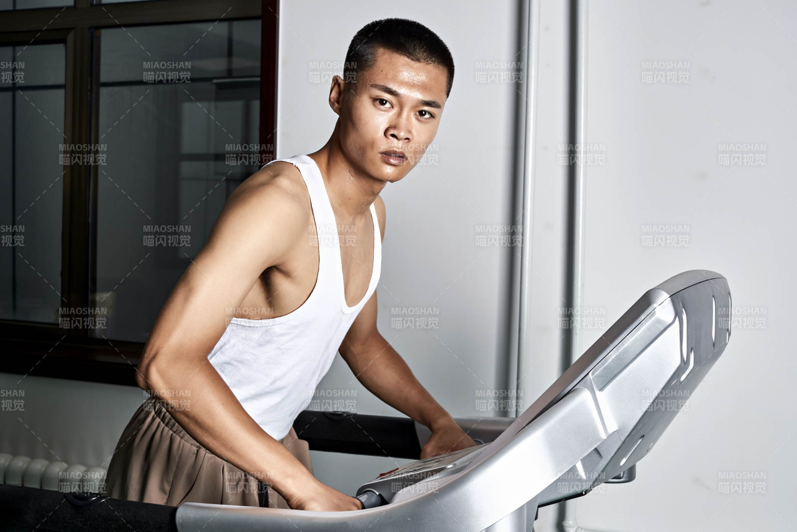 在室内用跑步机进行锻炼的亚洲健身男士形象图片