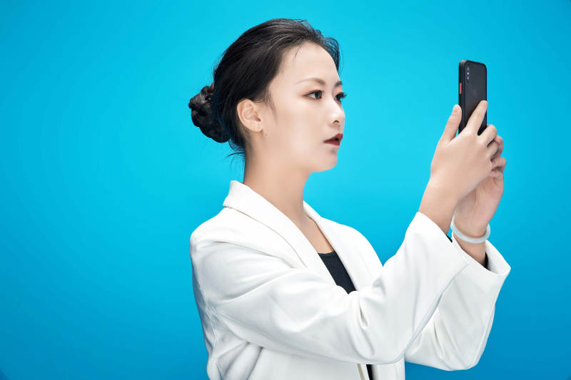 身穿西服拿着手机与文件夹的亚洲商务女士图片