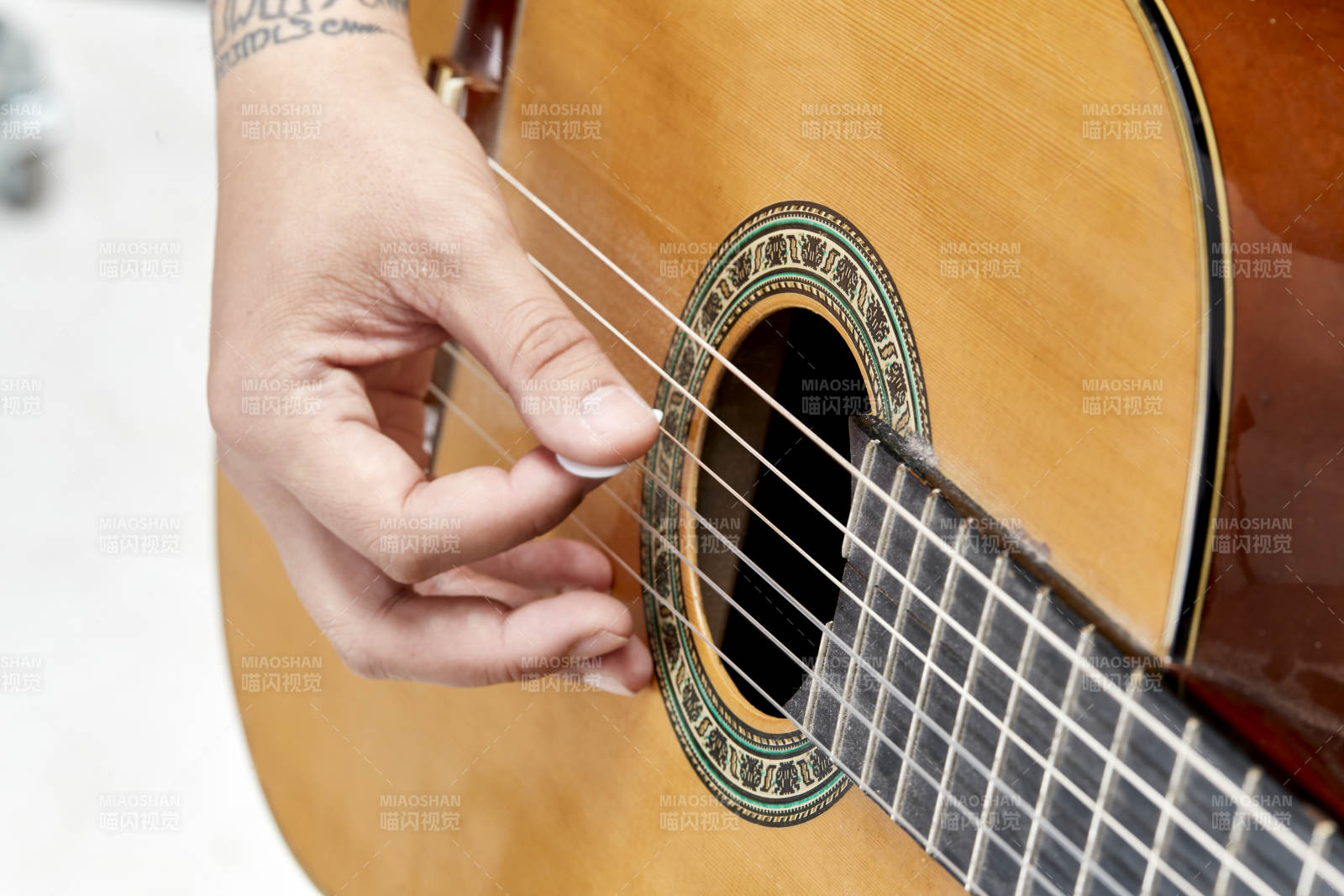 示范演奏古典吉他的亚洲男性乐手人像局部特写图片