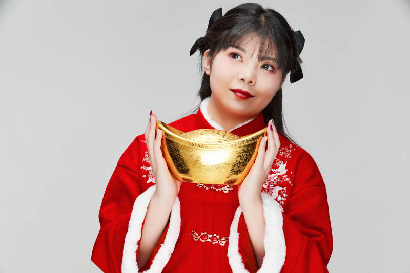 手捧金元宝身穿喜庆汉服的可爱少女图片