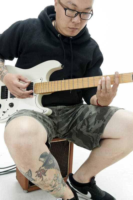 手持电吉他展示演奏的亚洲男性摇滚乐手人像图片