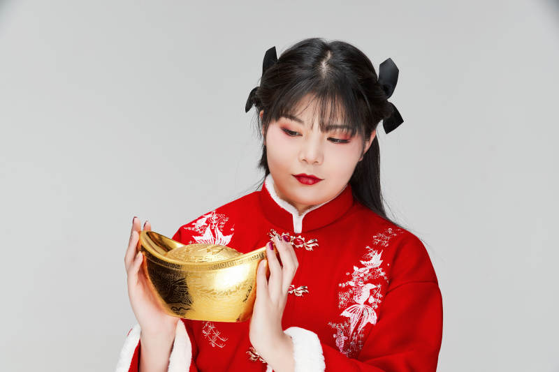 手捧金元宝身穿喜庆汉服的可爱少女图片