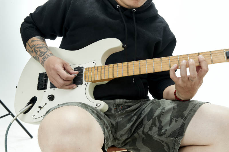 手持电吉他展示演奏的亚洲男性摇滚乐手人像图片