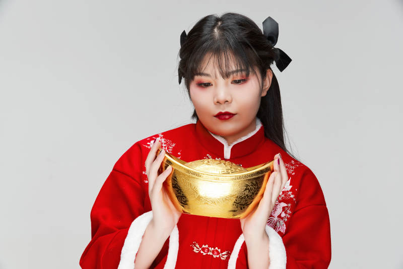 手捧金元宝身穿喜庆汉服的可爱少女图片