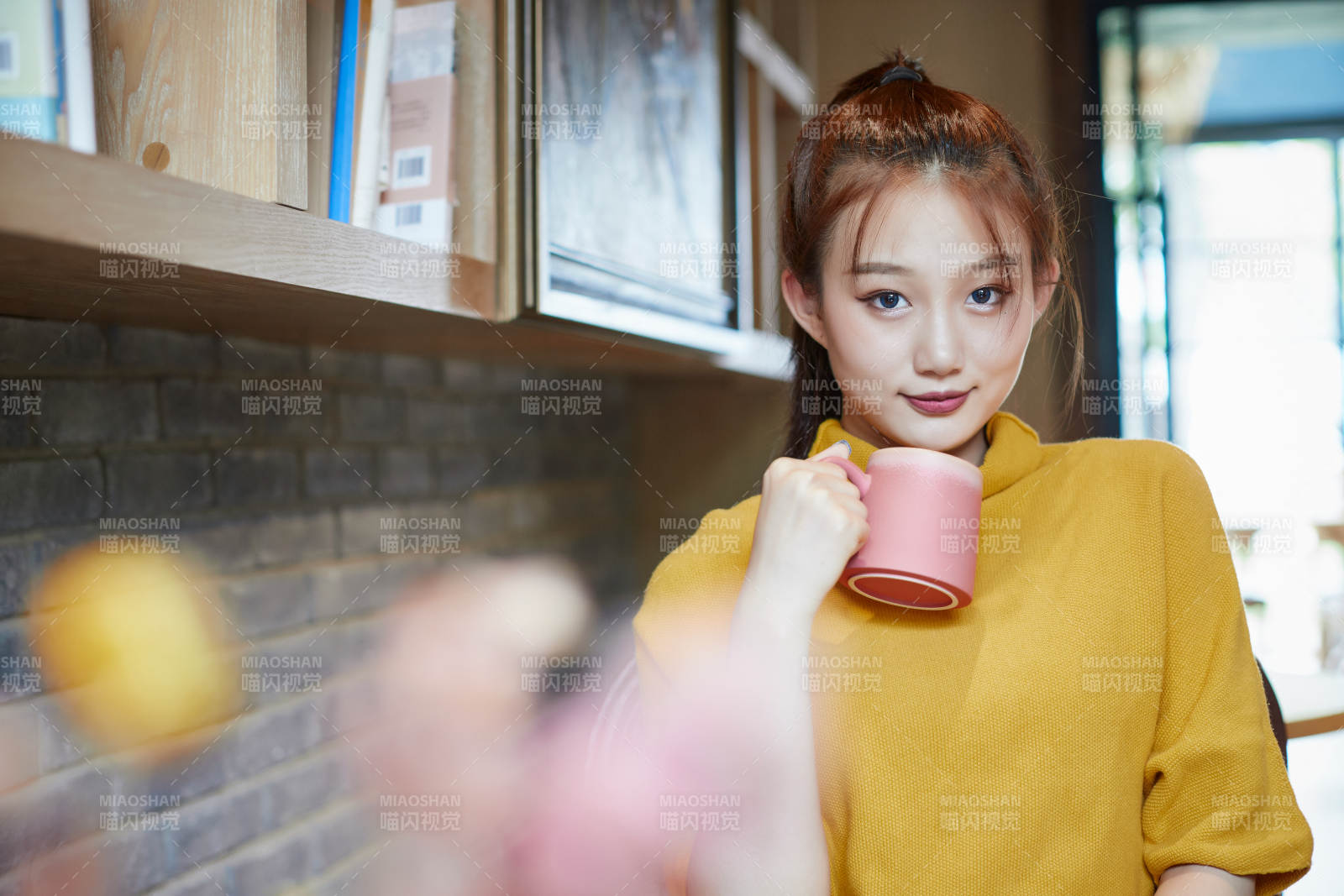 在图书咖啡馆阅读书籍的少女图片