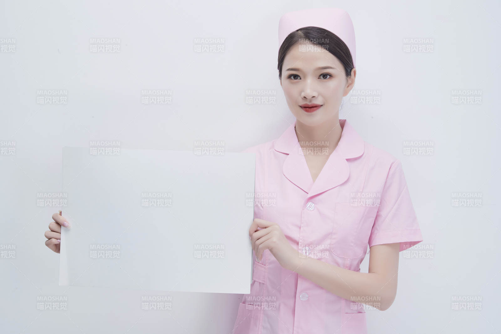 身穿粉色护士服佩戴听诊器的女性医护人员图片