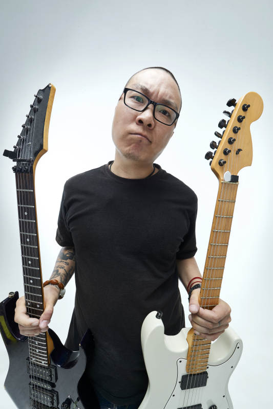 手持电吉他展示演奏的亚洲男性摇滚乐手人像图片