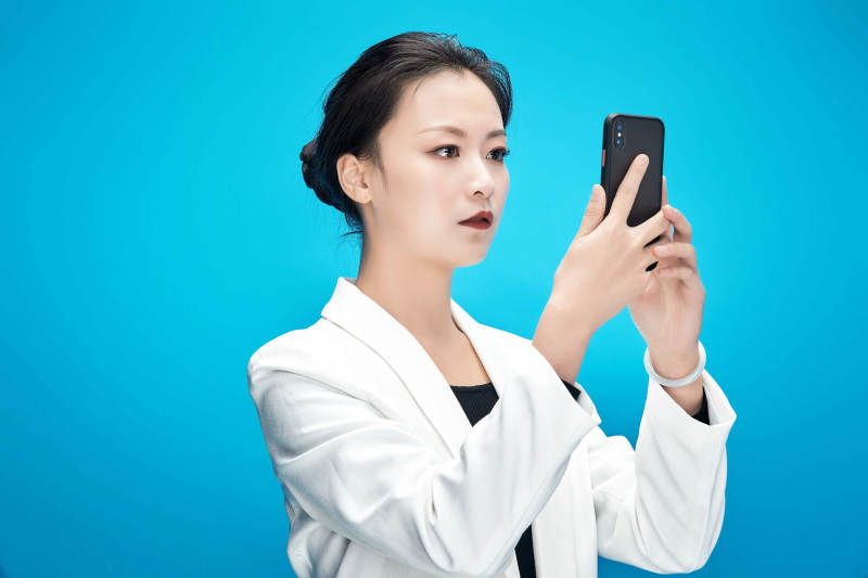 身穿西服拿着手机与文件夹的亚洲商务女士图片