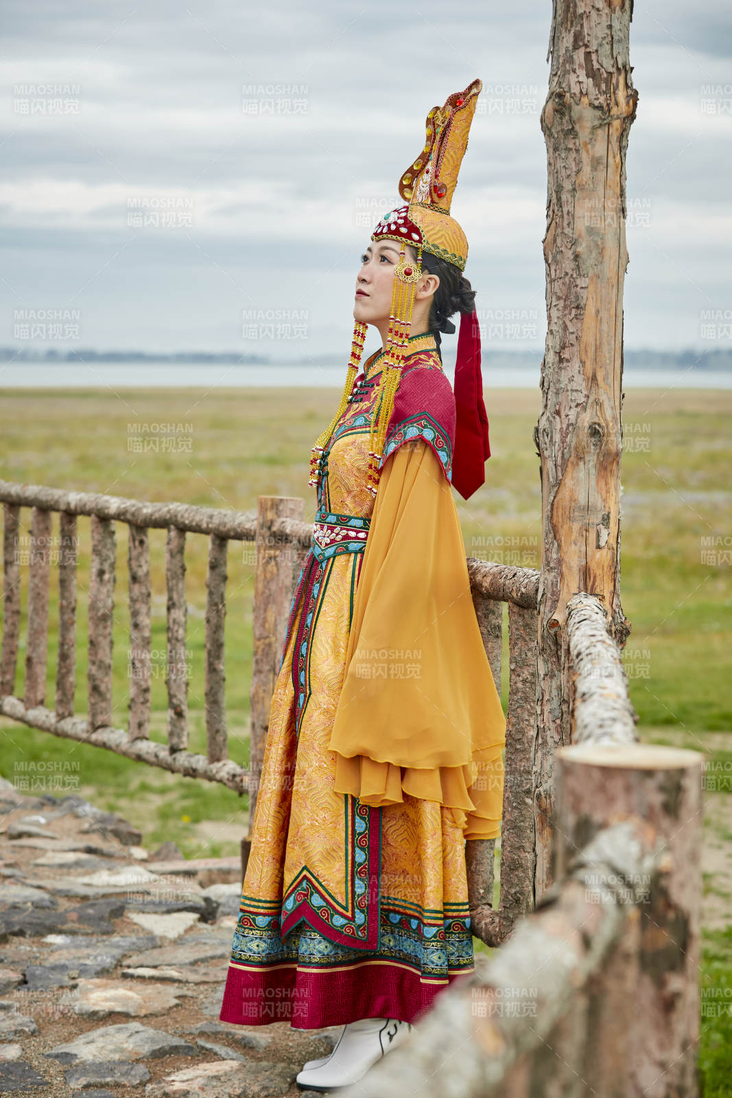 草原上敖包前身穿豪华蒙古族服饰的蒙族少女图片