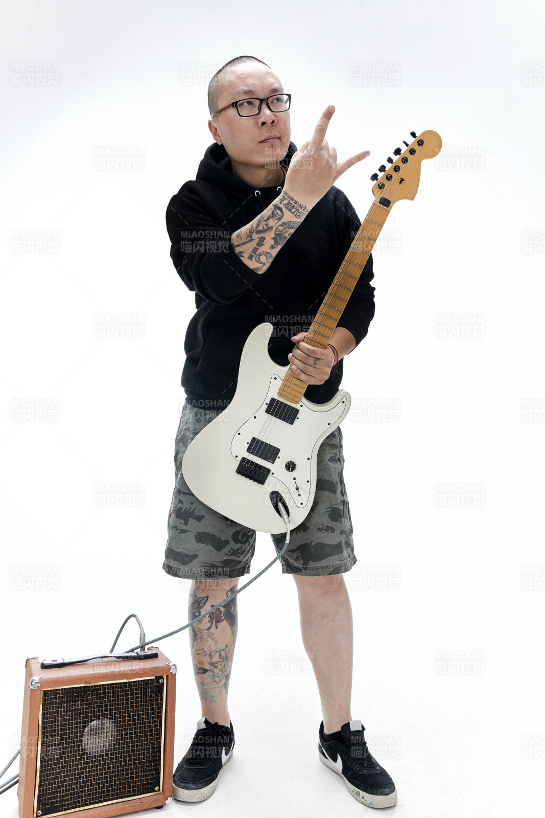 手持电吉他展示演奏的亚洲男性摇滚乐手人像图片