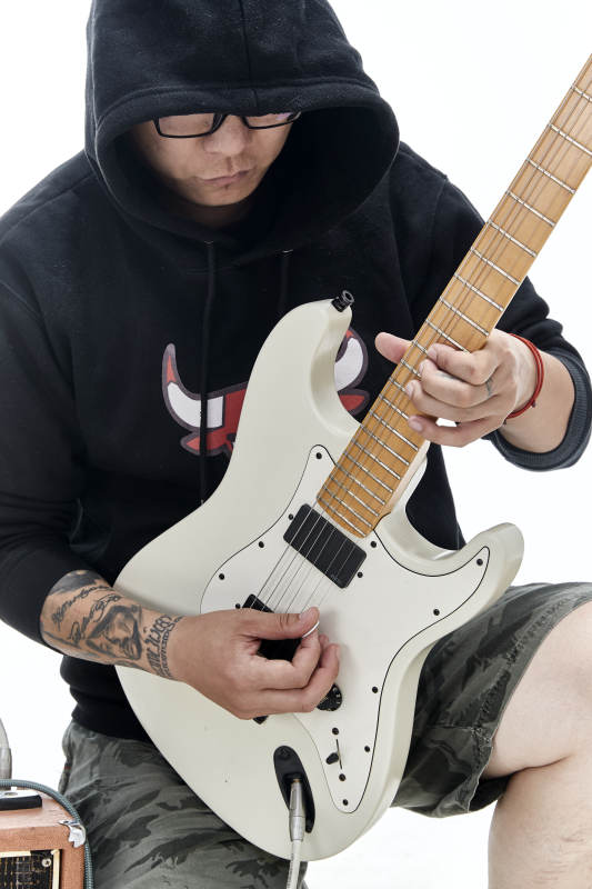 手持电吉他展示演奏的亚洲男性摇滚乐手人像图片