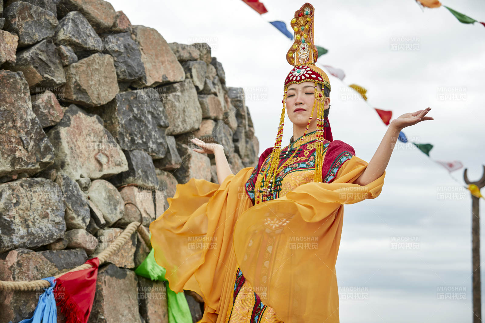 草原上敖包前身穿豪华蒙古族服饰的蒙族少女图片