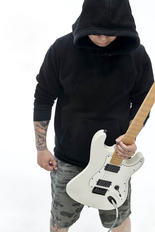 手持电吉他展示演奏的亚洲男性摇滚乐手人像图片