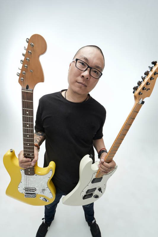 手持电吉他展示演奏的亚洲男性摇滚乐手人像图片