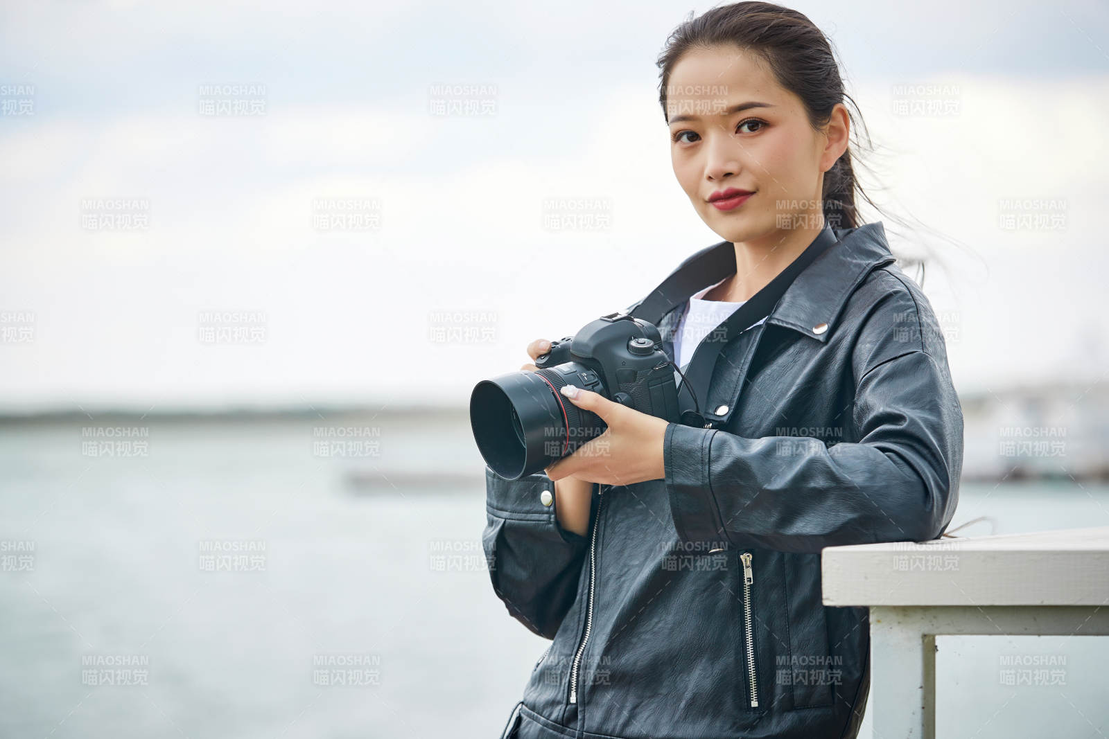 户外湖畔进行拍摄的亚洲青年女性摄影师图片