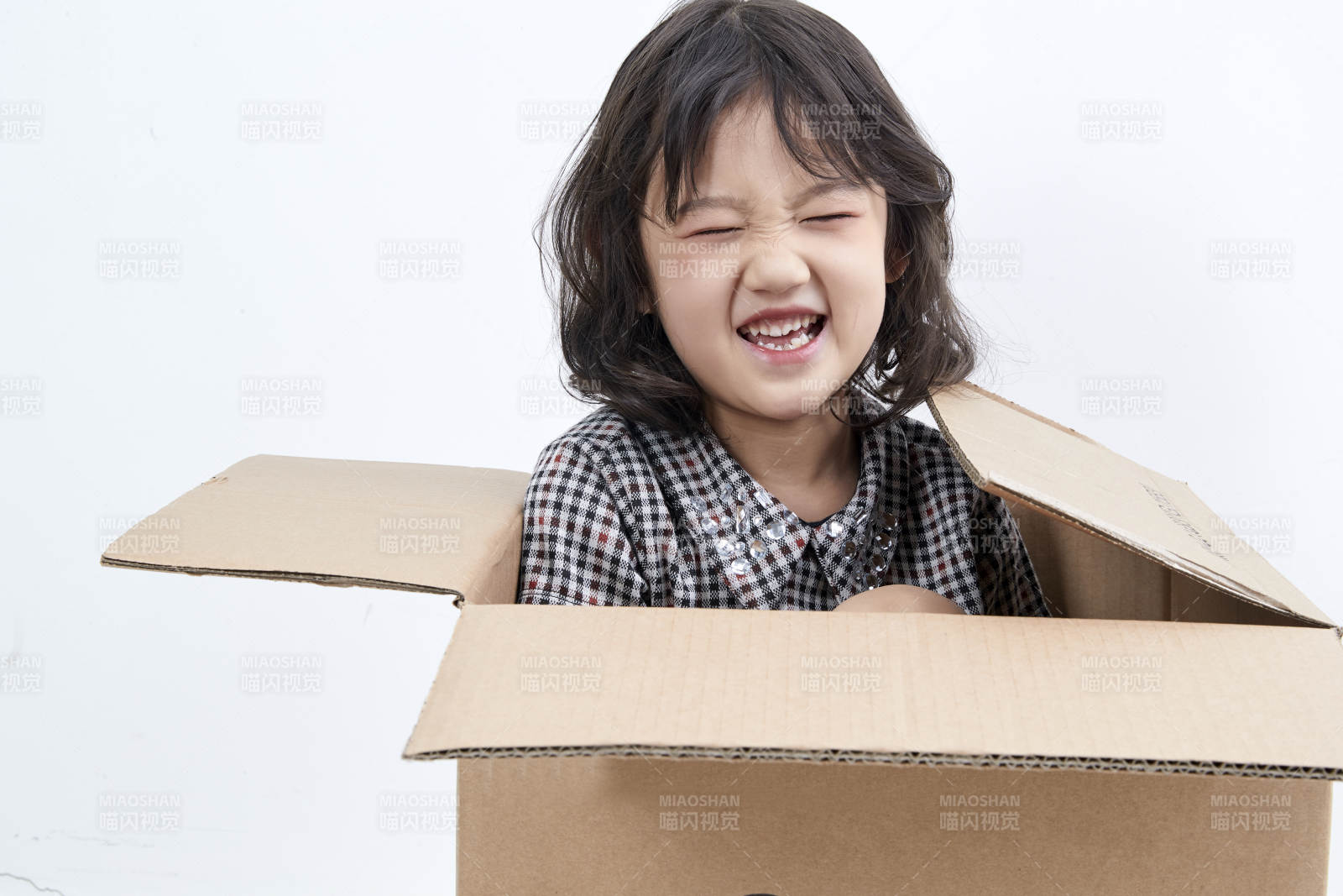 躲在纸箱中玩耍的调皮可爱亚洲小女孩儿童图片