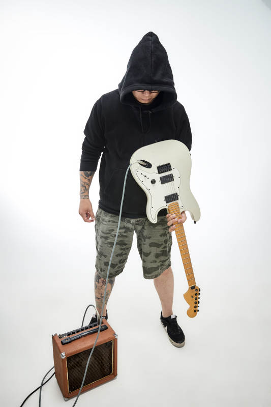 手持电吉他展示演奏的亚洲男性摇滚乐手人像图片