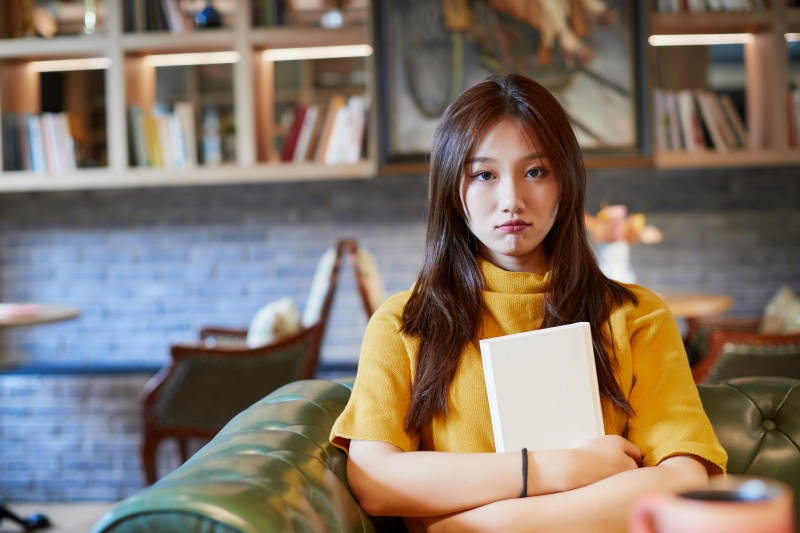 在图书咖啡馆阅读书籍的少女图片