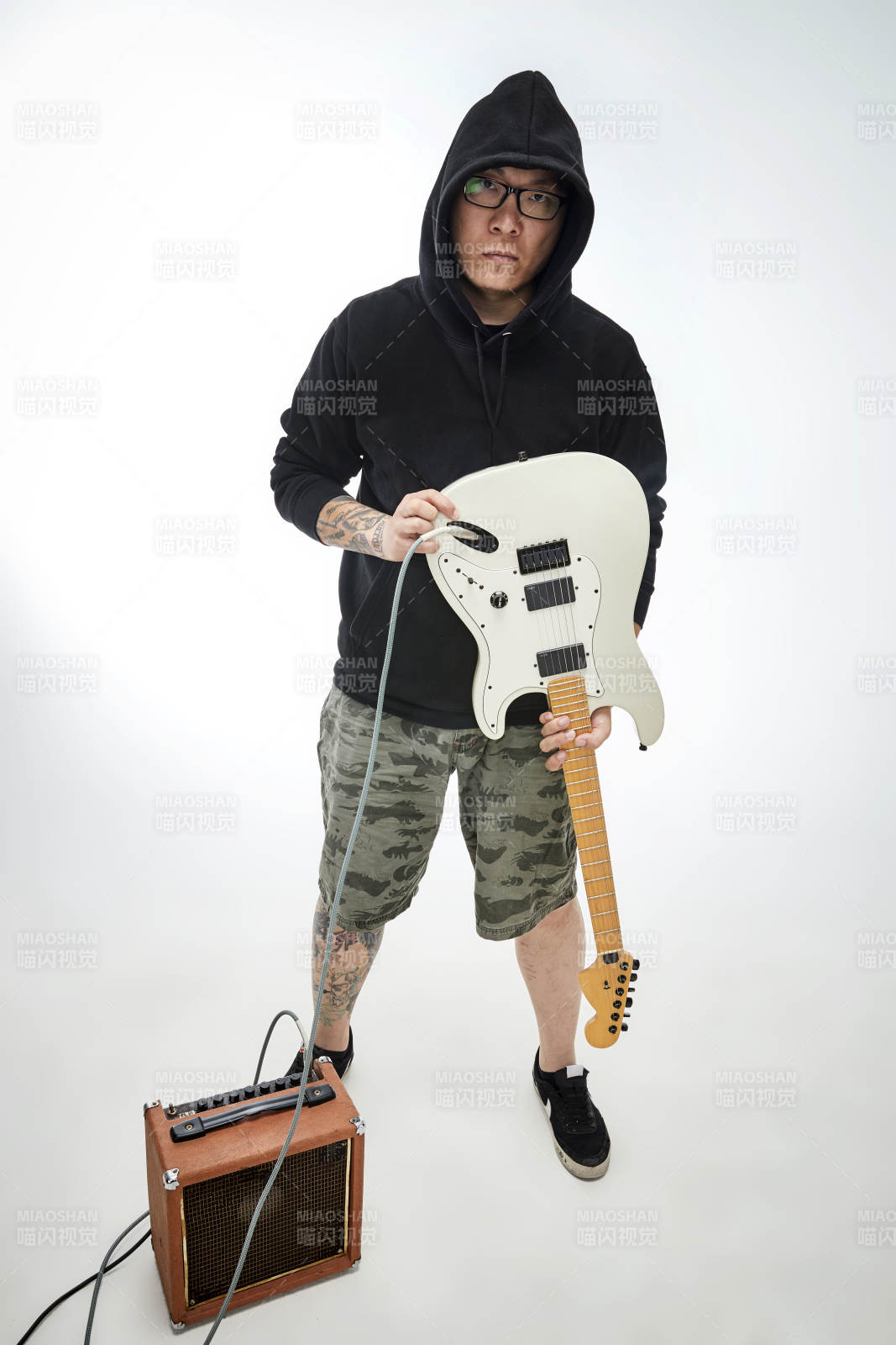 手持电吉他展示演奏的亚洲男性摇滚乐手人像图片