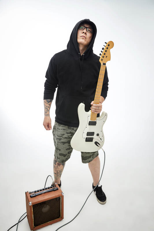 手持电吉他展示演奏的亚洲男性摇滚乐手人像图片