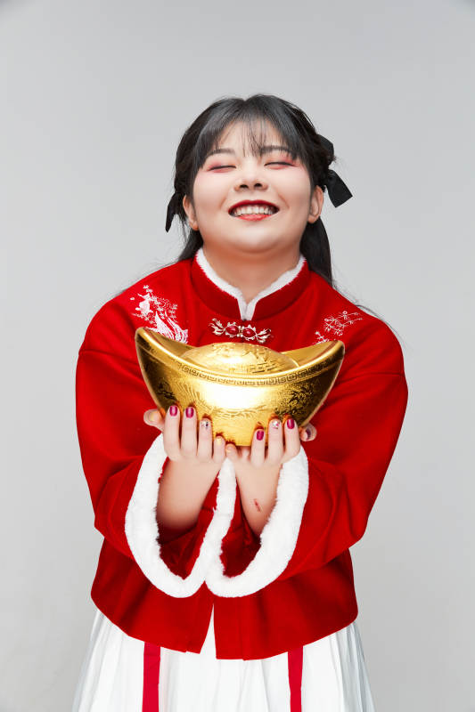 手捧金元宝身穿喜庆汉服的可爱少女图片
