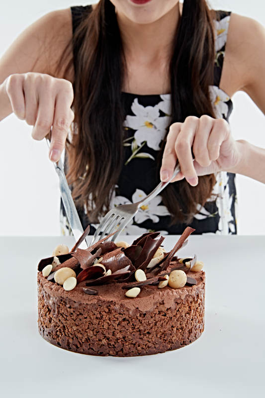 喝红酒品尝蛋糕的年轻女性图片