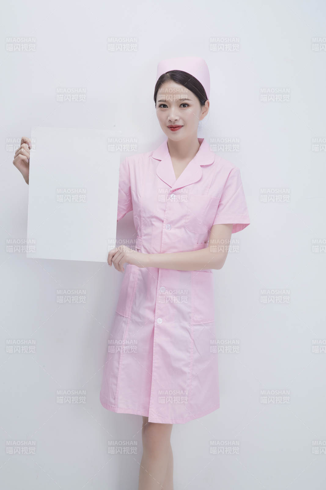 身穿粉色护士服佩戴听诊器的女性医护人员图片