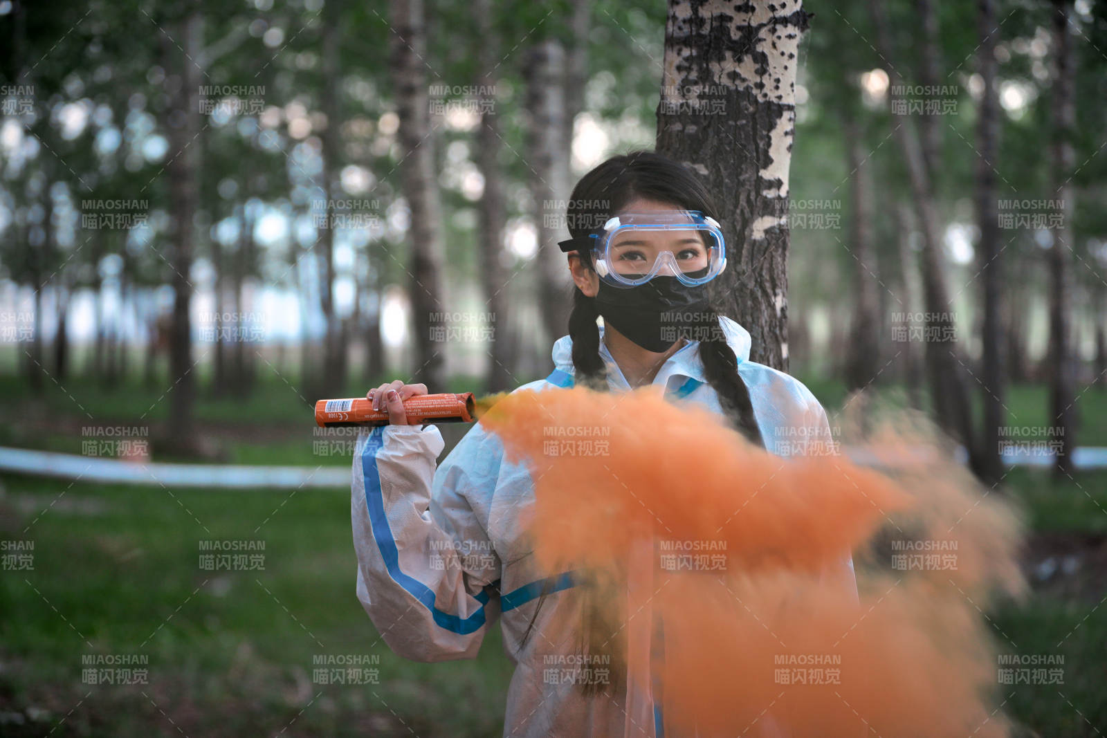 手执彩烟身穿防护服装的女性医疗人员图片