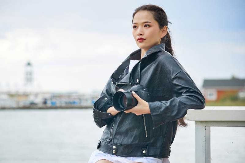 户外湖畔进行拍摄的亚洲青年女性摄影师图片