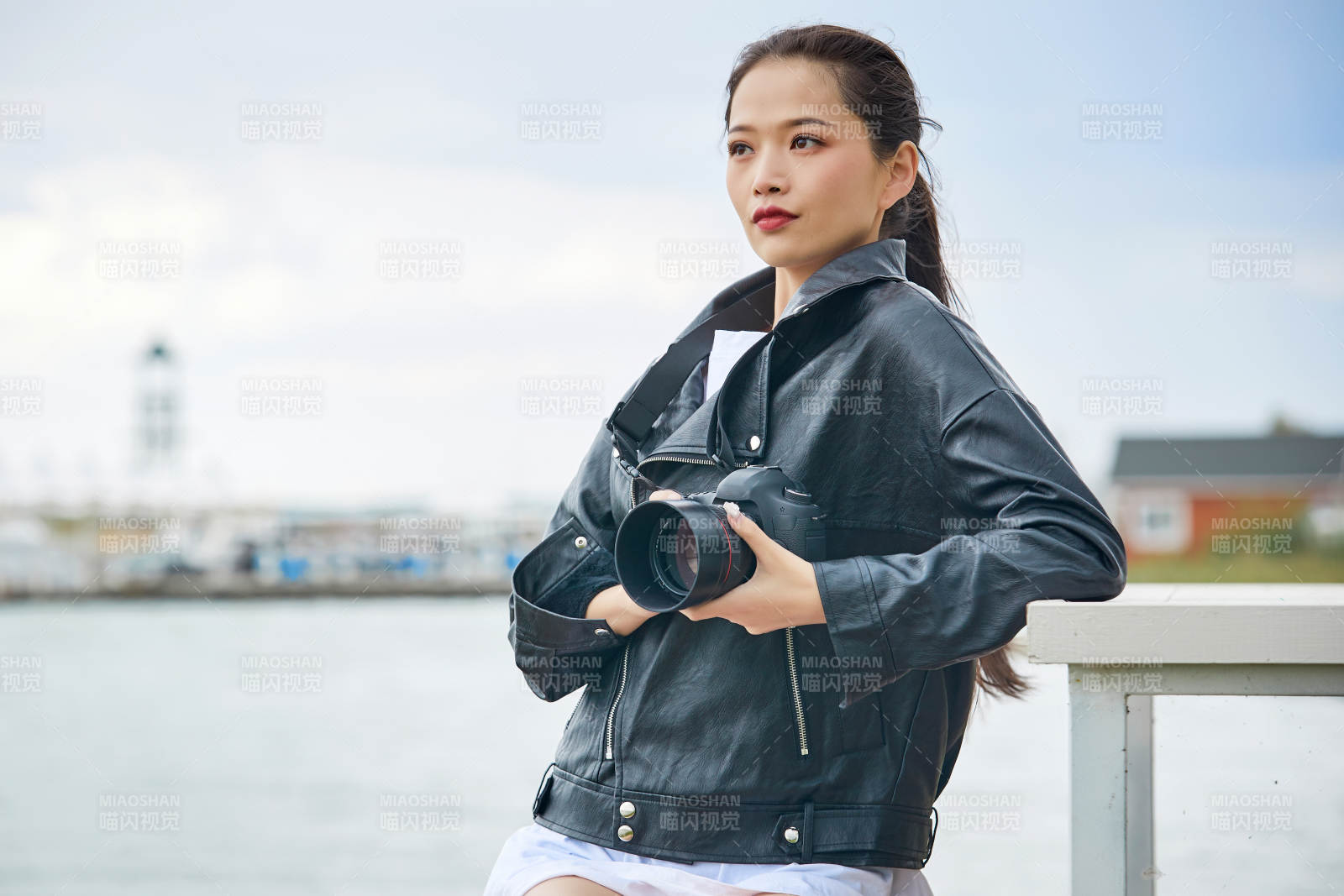 户外湖畔进行拍摄的亚洲青年女性摄影师图片