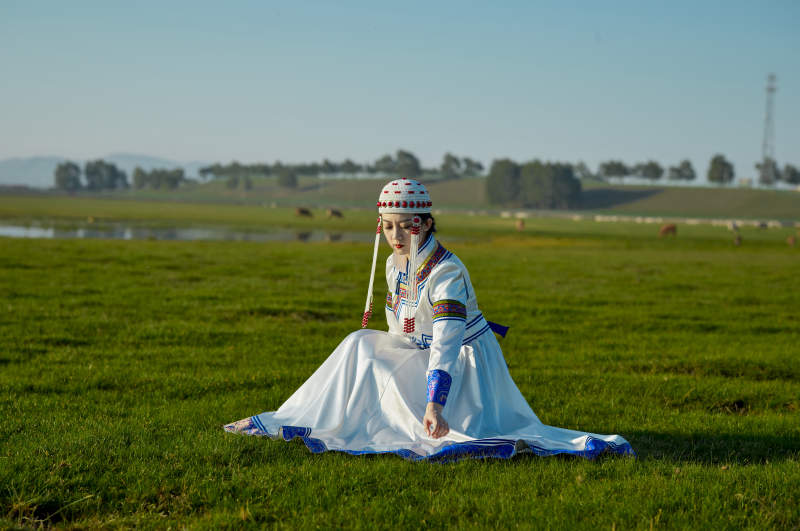 草原上穿着蒙古族传统服饰的亚洲年轻美少女图片