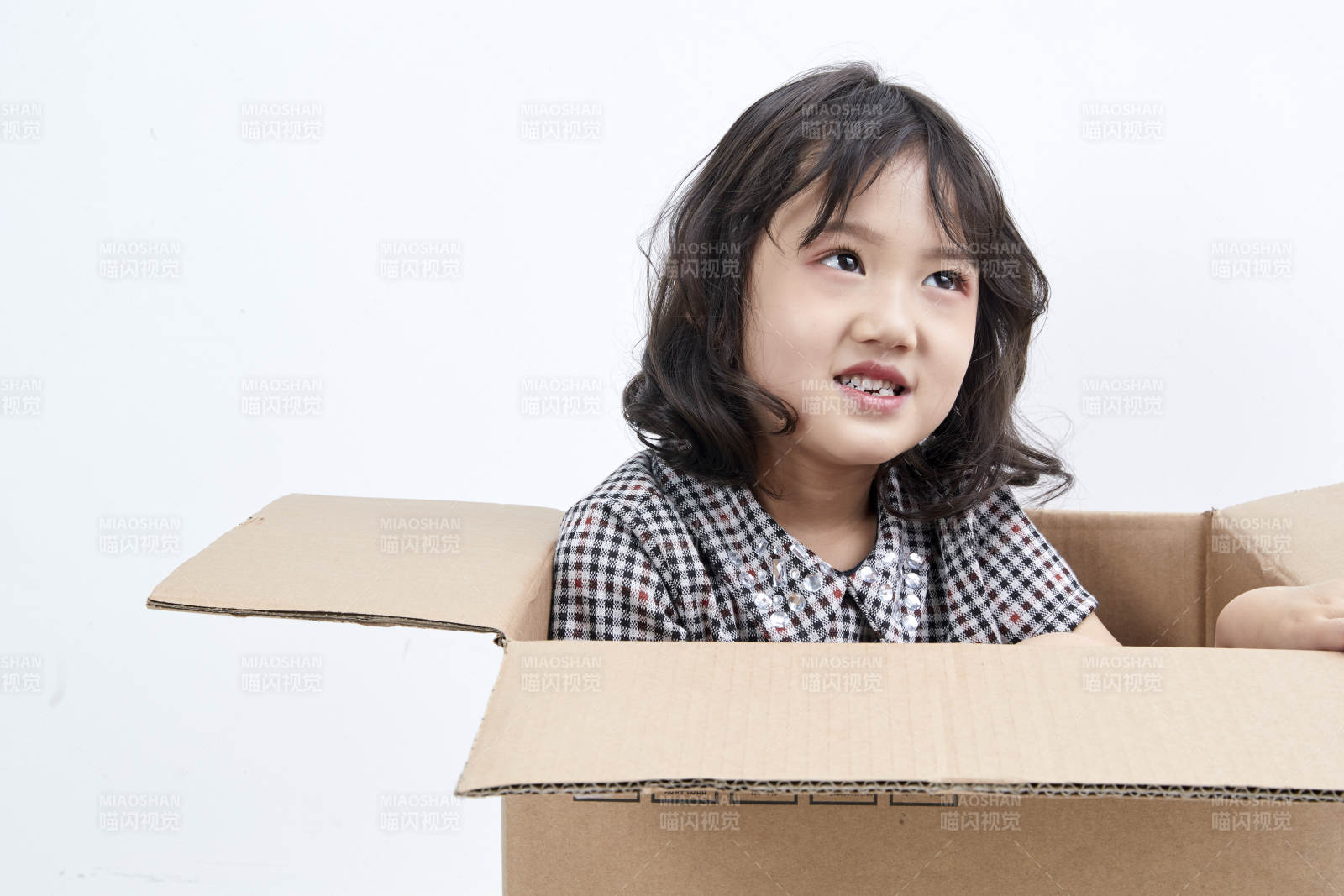躲在纸箱中玩耍的调皮可爱亚洲小女孩儿童图片