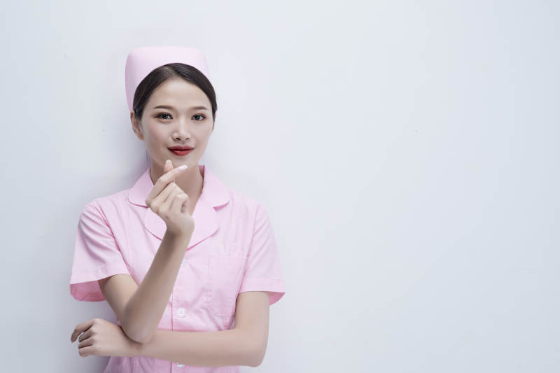 身穿粉色护士服佩戴听诊器的女性医护人员图片