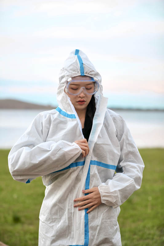 穿白色防护服佩戴护目镜口罩的女性防护人员图片