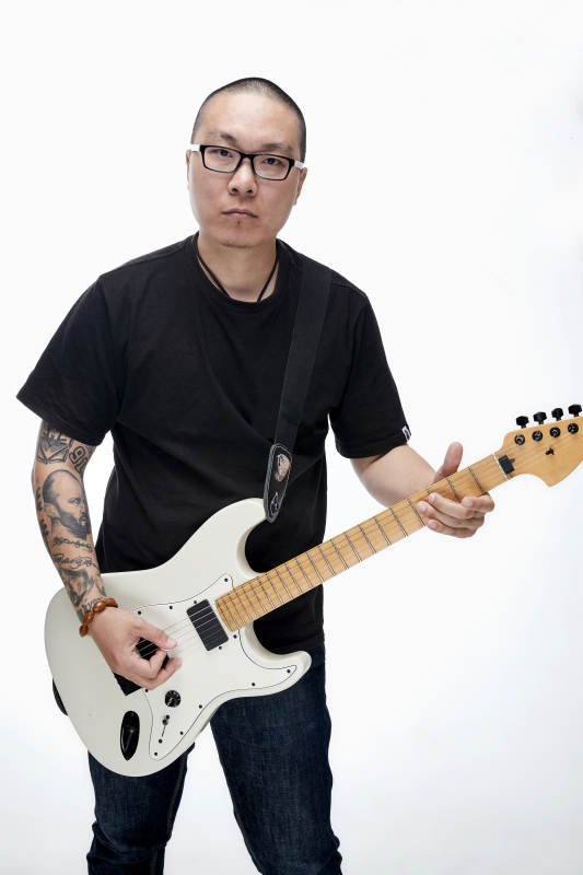 手持电吉他展示演奏的亚洲男性摇滚乐手人像图片