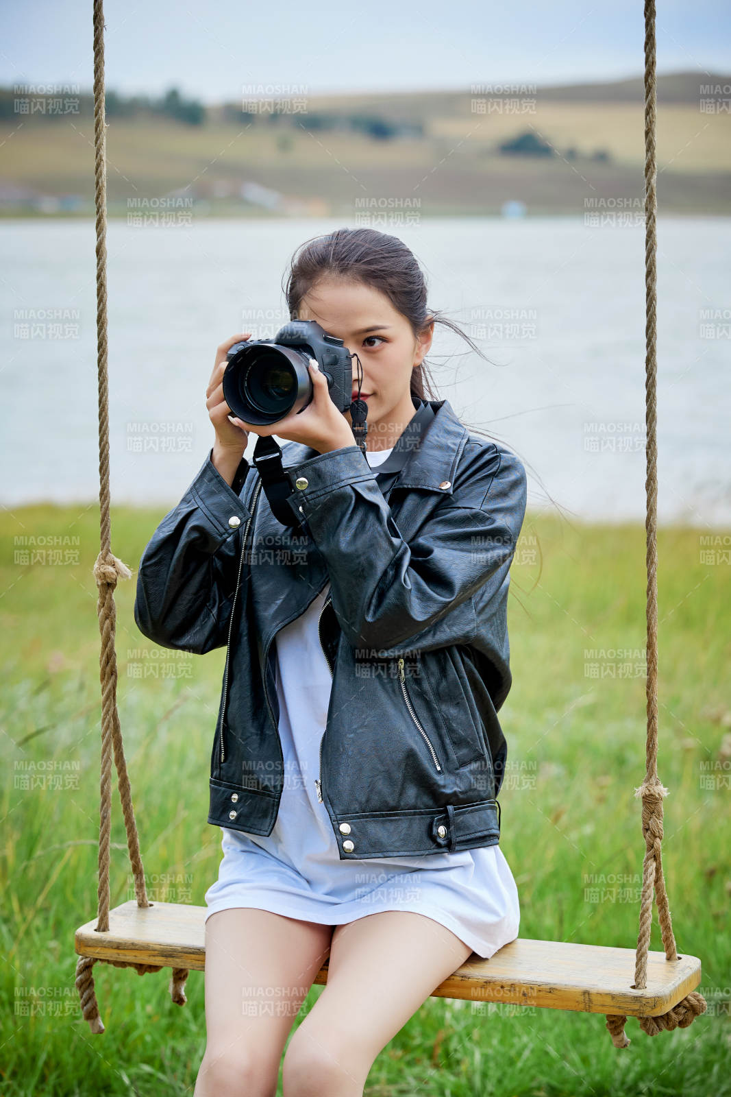 户外湖畔进行拍摄的亚洲青年女性摄影师图片