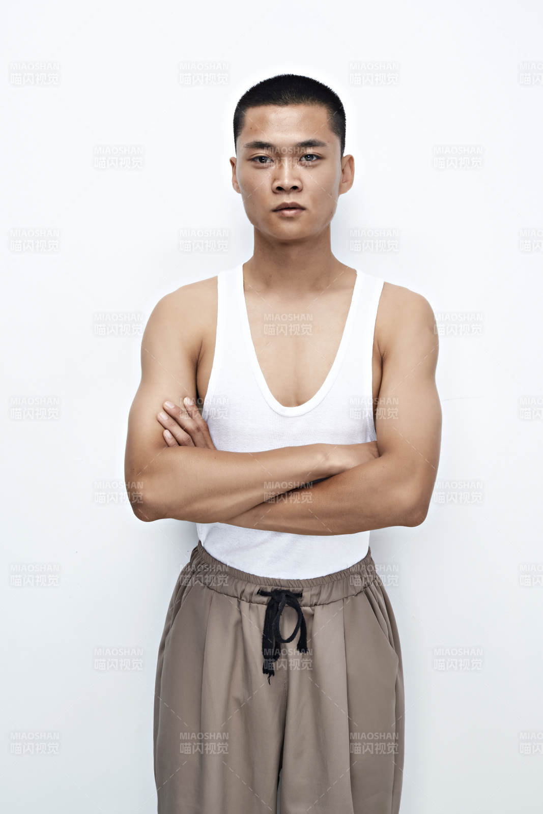 白色背景下展示健身预备拉伸动作的亚洲男性图片