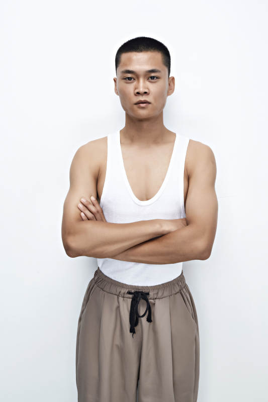 白色背景下展示健身预备拉伸动作的亚洲男性图片