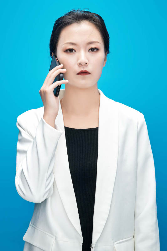 身穿西服拿着手机与文件夹的亚洲商务女士图片