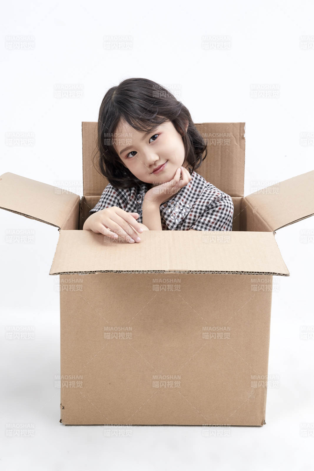 躲在纸箱中玩耍的调皮可爱亚洲小女孩儿童图片