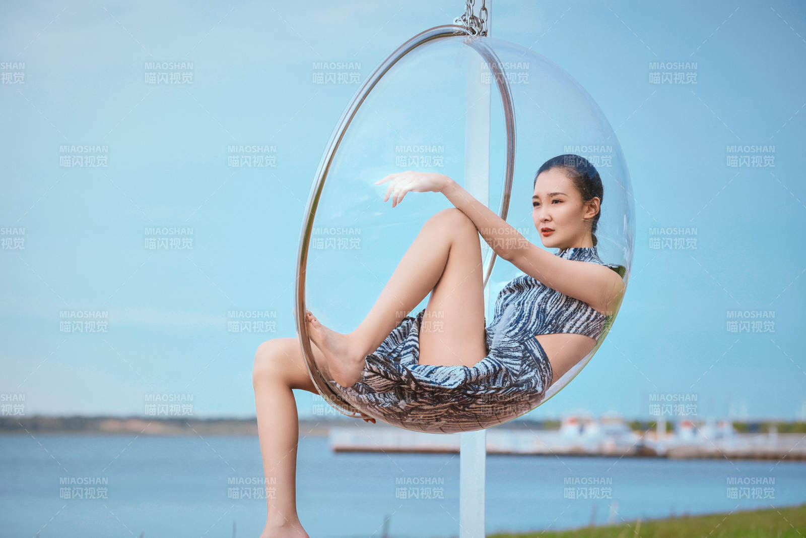 草原湖畔坐在透明秋千里的亚洲年轻女性人像图片