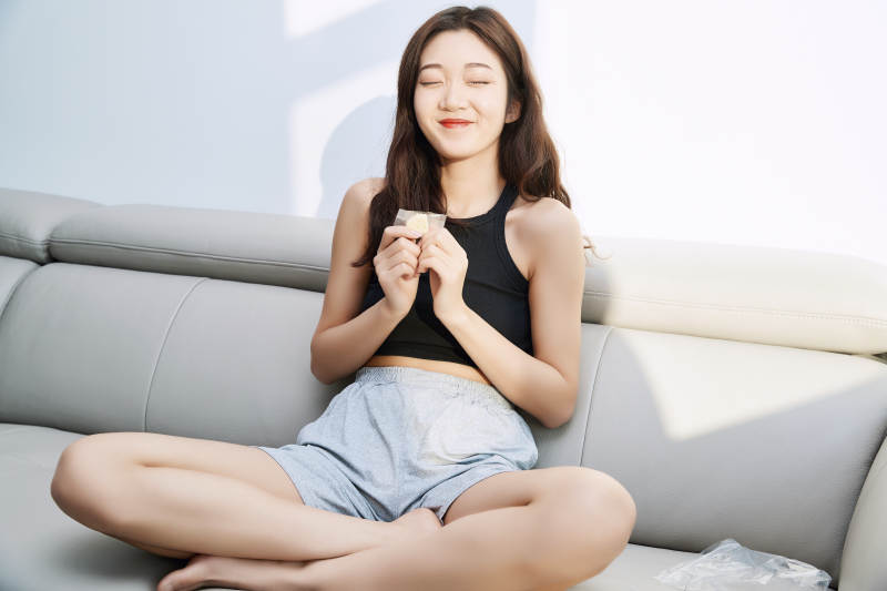 在家在沙发上享受美食的亚洲少女图片