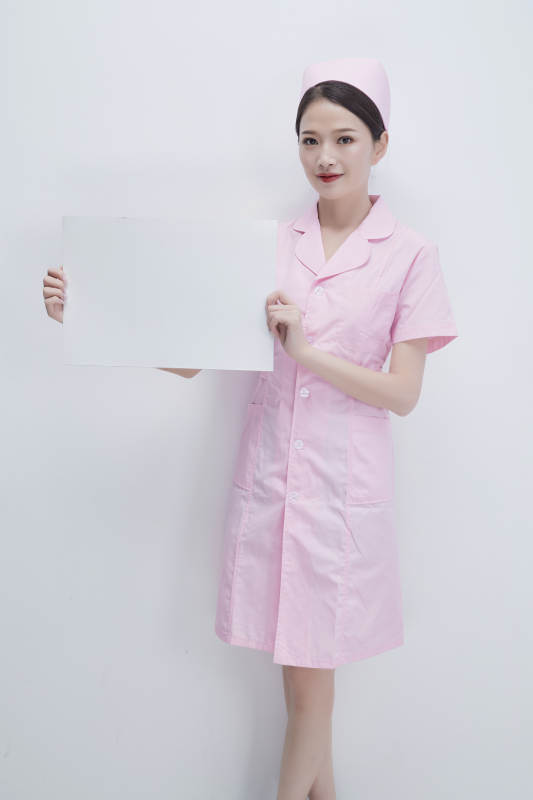 身穿粉色护士服佩戴听诊器的女性医护人员图片